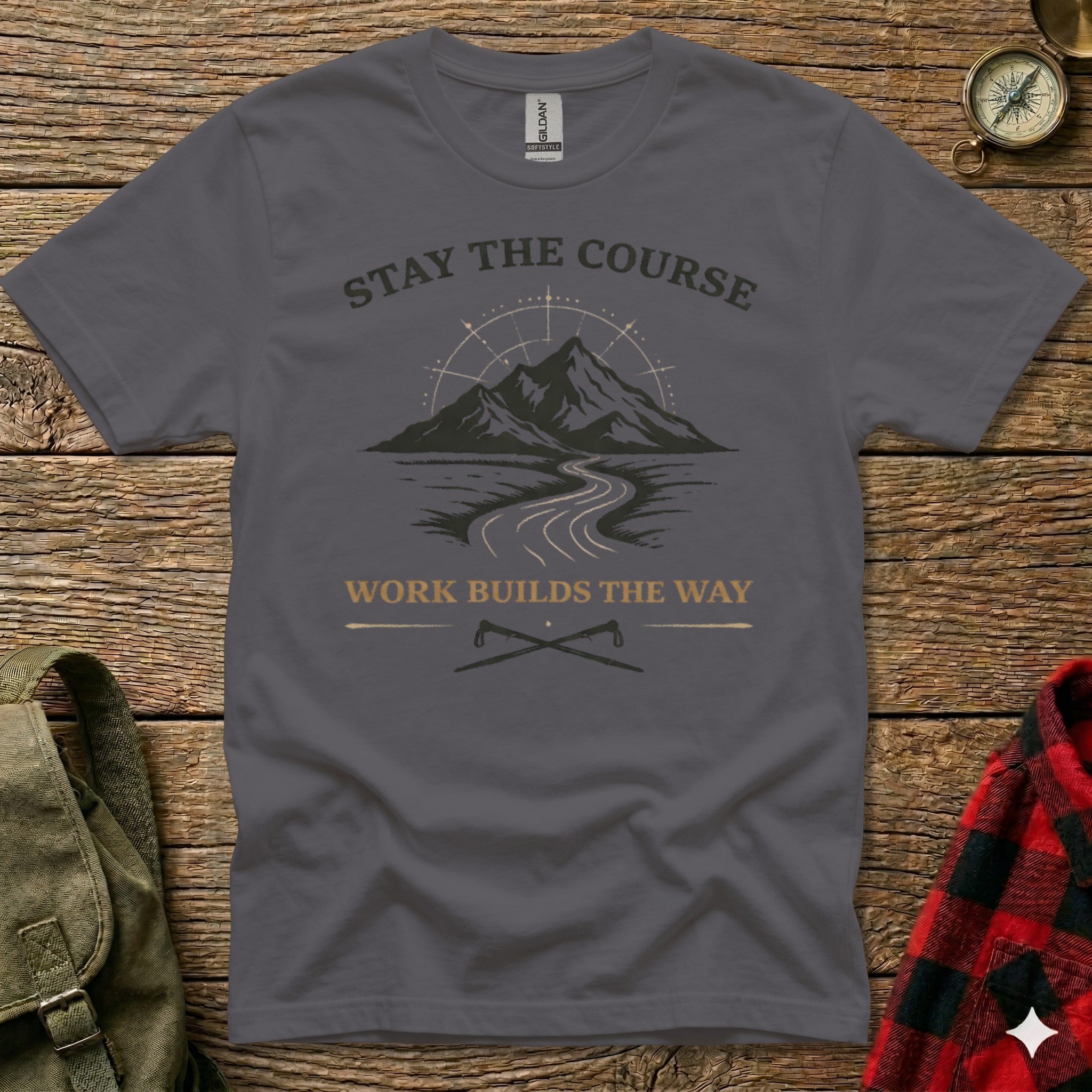 Dark grey t-shirt with mountain, road, and compass design, text "STAY THE COURSE WORK BUILDS THE WAY".