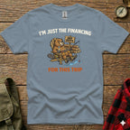 Blue t-shirt with a cartoon beaver fishing, "I'm Just the Financing Off Duty For This Trip" text.