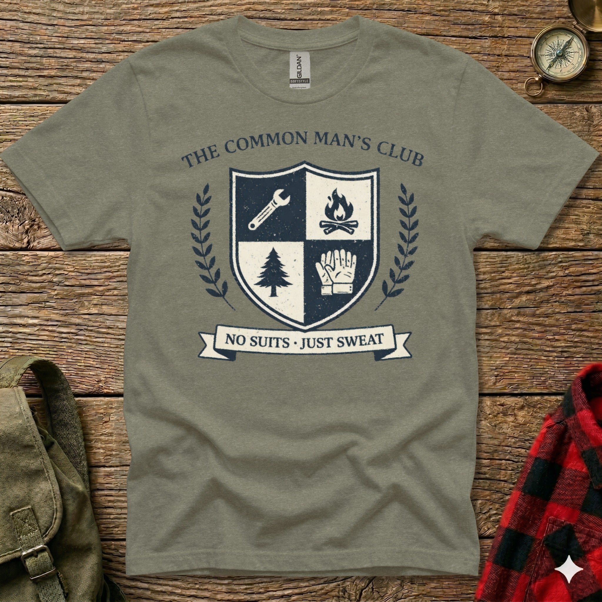 Olive green t-shirt with "The Common Man's Club" emblem and "No Suits Just Sweat" banner.
