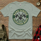 Green t-shirt with "Hard Earned Wilderness Bound Forestry & Hunting Equip." logo.