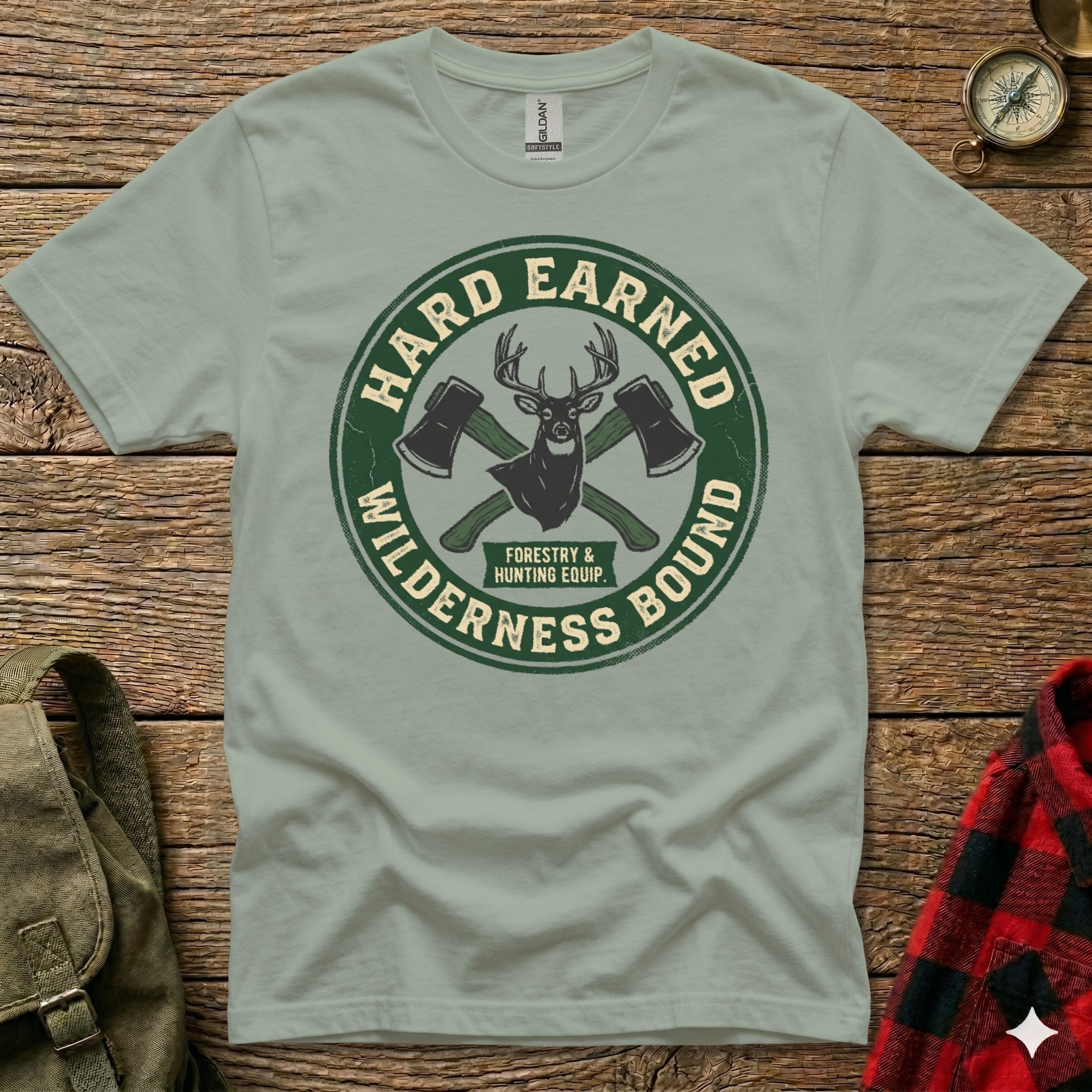 Green t-shirt with "Hard Earned Wilderness Bound Forestry & Hunting Equip." logo.