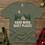 Green t-shirt with "HARD WORK QUIET PLACES" and forest cabin graphic.