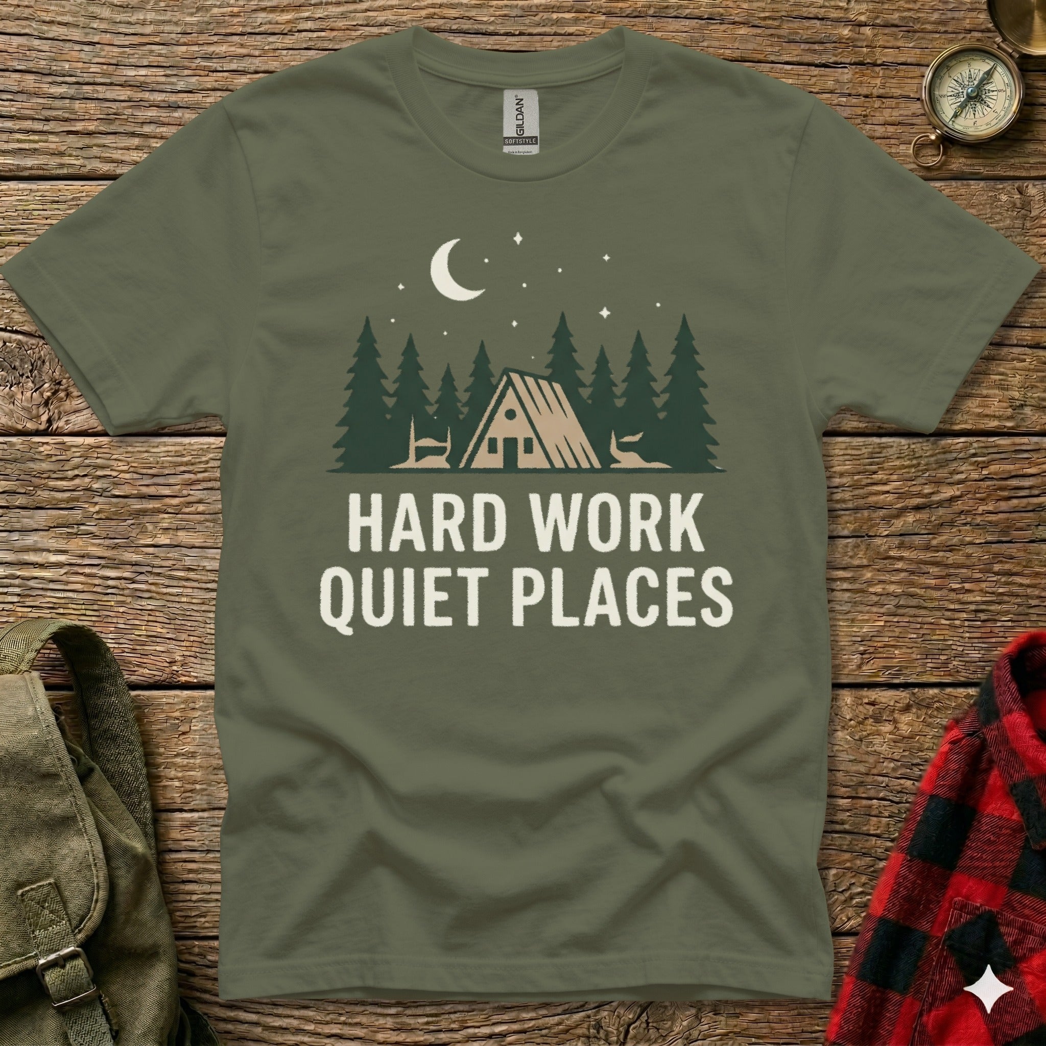 Green t-shirt with "HARD WORK QUIET PLACES" and forest cabin graphic.