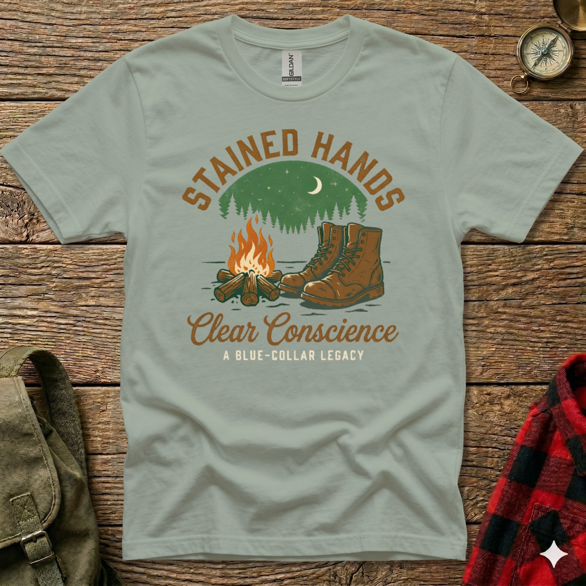 T-shirt with "Stained Hands, Clear Conscience" and boots by campfire.
