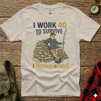 Cream t-shirt with cartoon man leaning on firewood, text "I WORK 40 TO SURVIVE" and "I TRESPASS TO THRIVE".