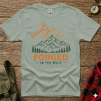 T-shirt graphic with hammer, mountains, trees, and text "FORGED - IN THE WILD".