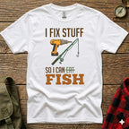White t-shirt with text "I FIX STUFF SO I CAN EAT FISH" and illustrations.