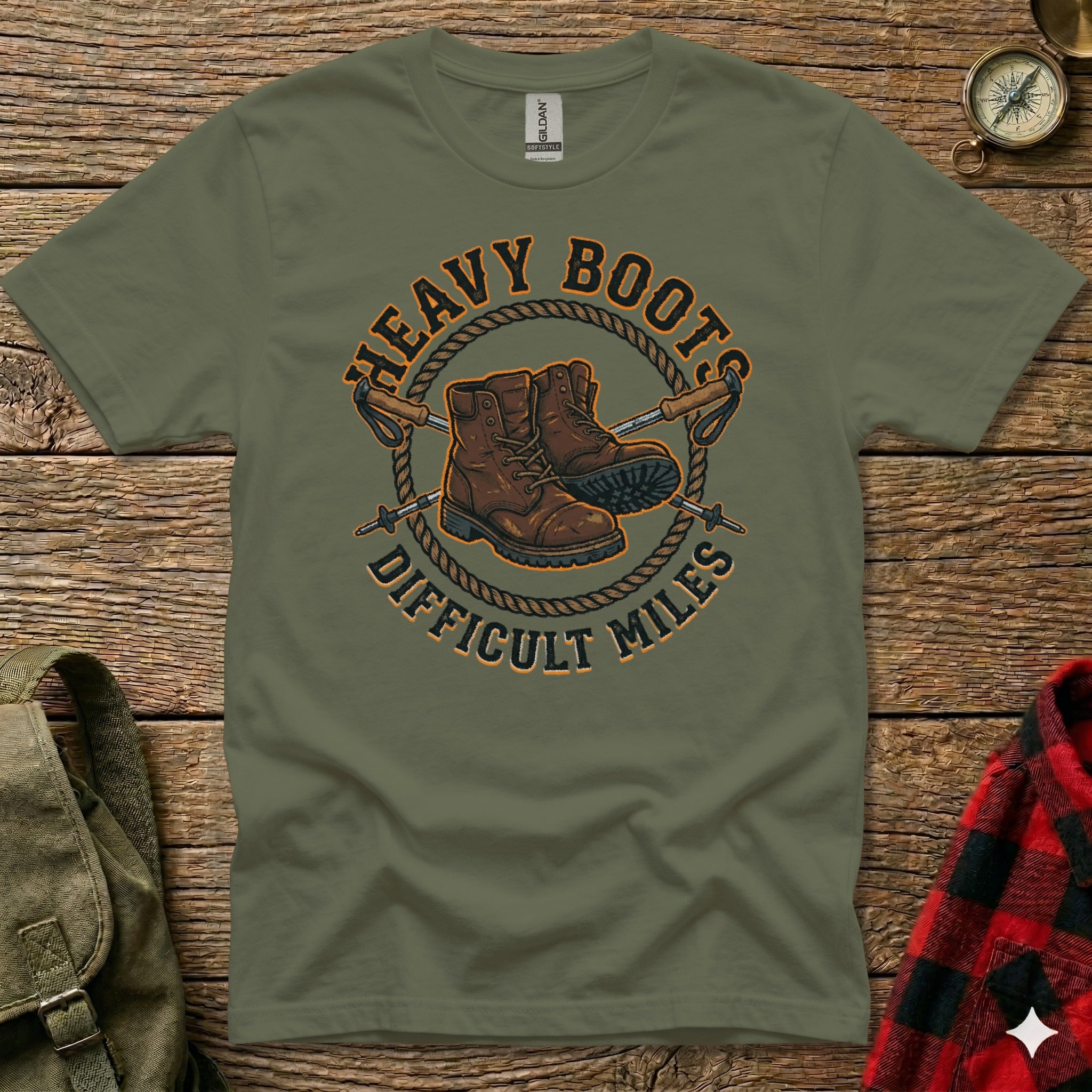 Olive green t-shirt with boots and poles graphic: "Heavy Boots Difficult Miles".