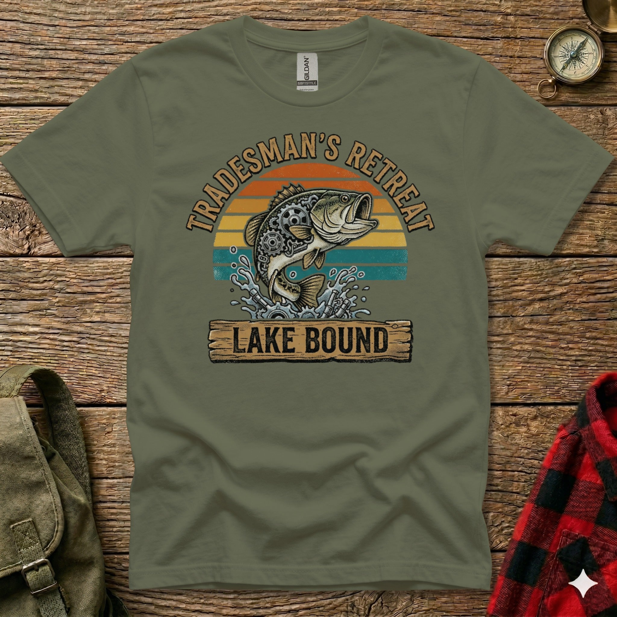 Olive green t-shirt with "Tradesman's Retreat Lake Bound" text and jumping fish graphic.