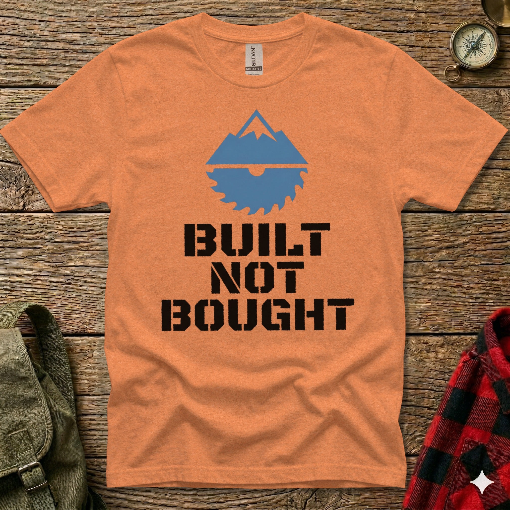 Orange t-shirt with "BUILT NOT BOUGHT" text and mountain graphic.