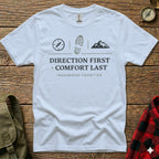 White t-shirt with compass, boot print, and mountain graphic, text reads "DIRECTION FIRST COMFORT LAST IRONWOOD FRONTIER".
