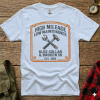 White t-shirt with distressed orange graphic of crossed wrench and hammer, "HIGH MILEAGE LOW MAINTENANCE" text.