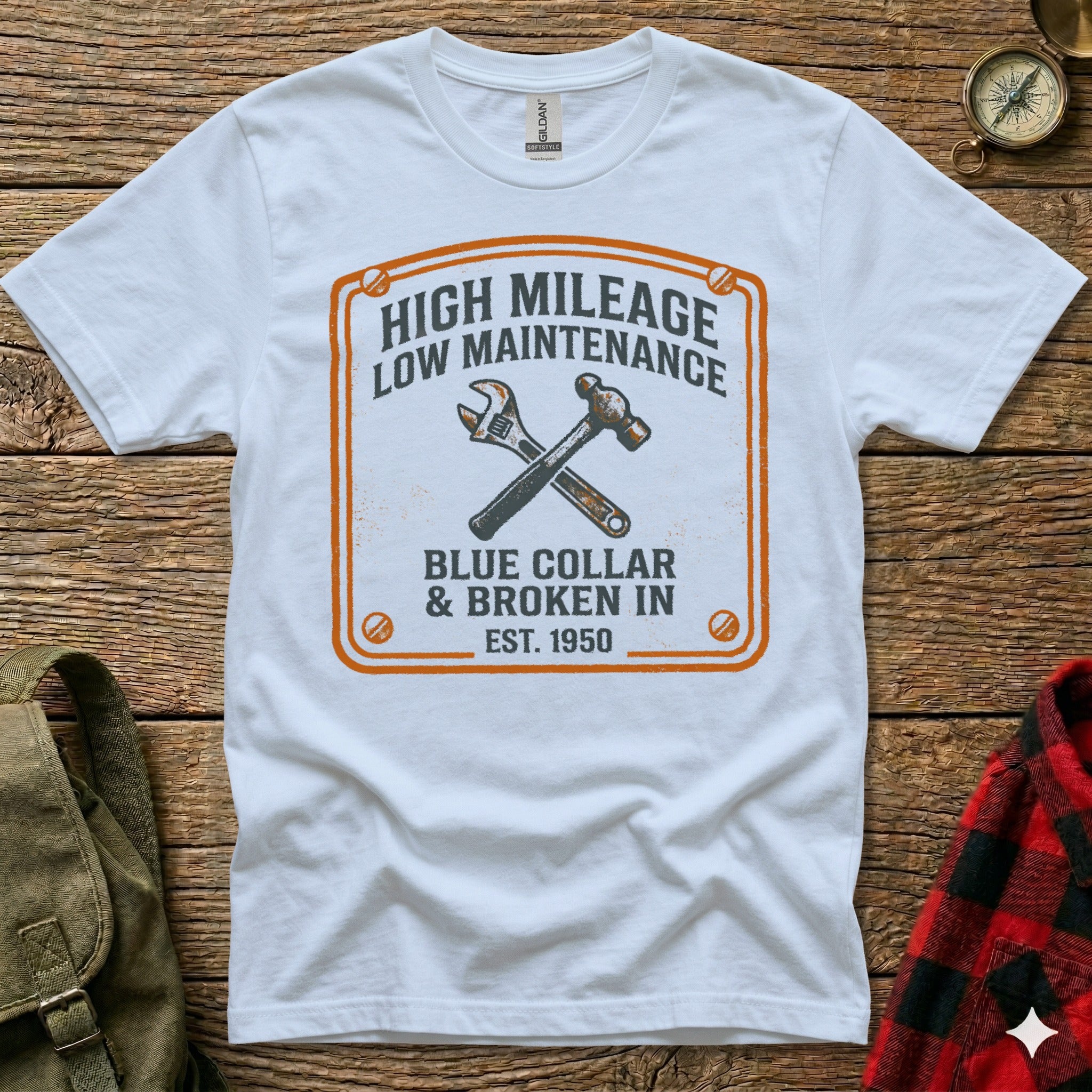 White t-shirt with distressed orange graphic of crossed wrench and hammer, "HIGH MILEAGE LOW MAINTENANCE" text.