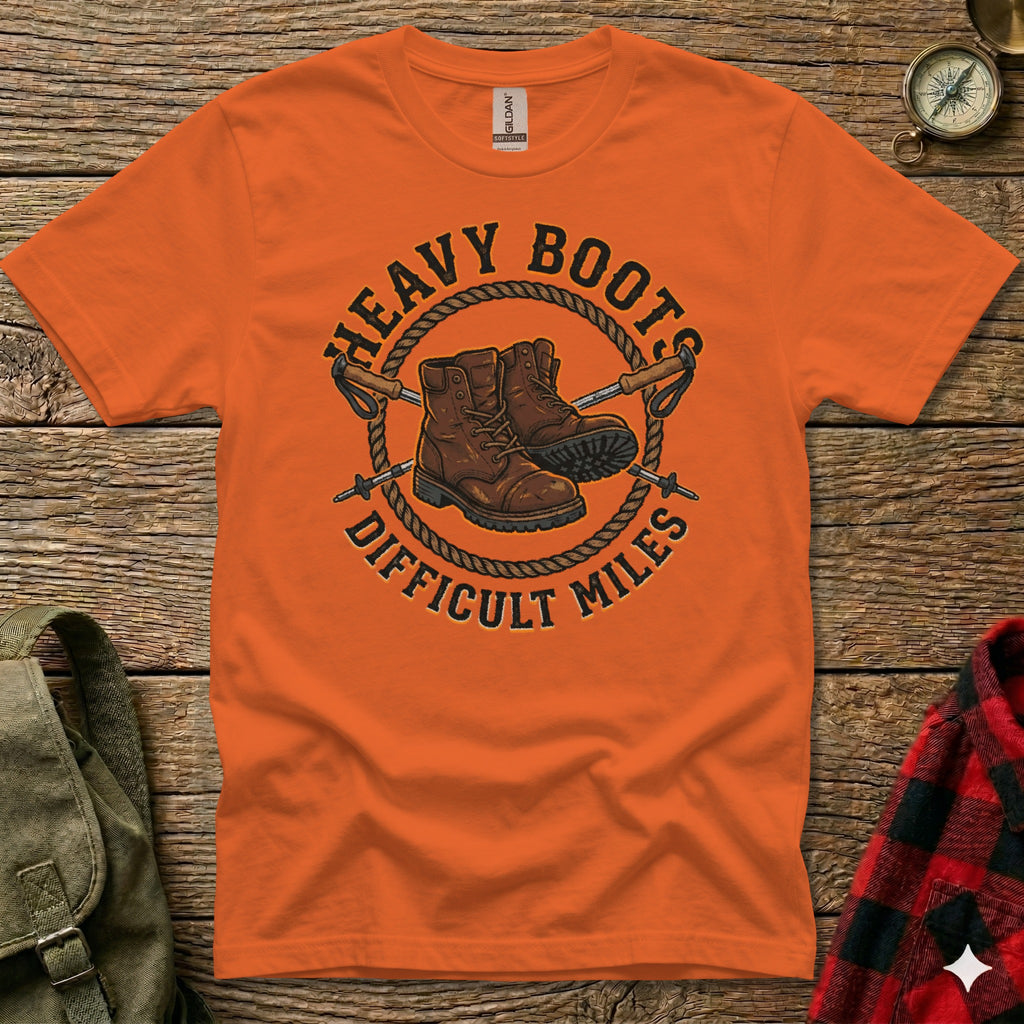 Orange t-shirt with "Heavy Boots Difficult Miles" graphic of boots and hiking poles.
