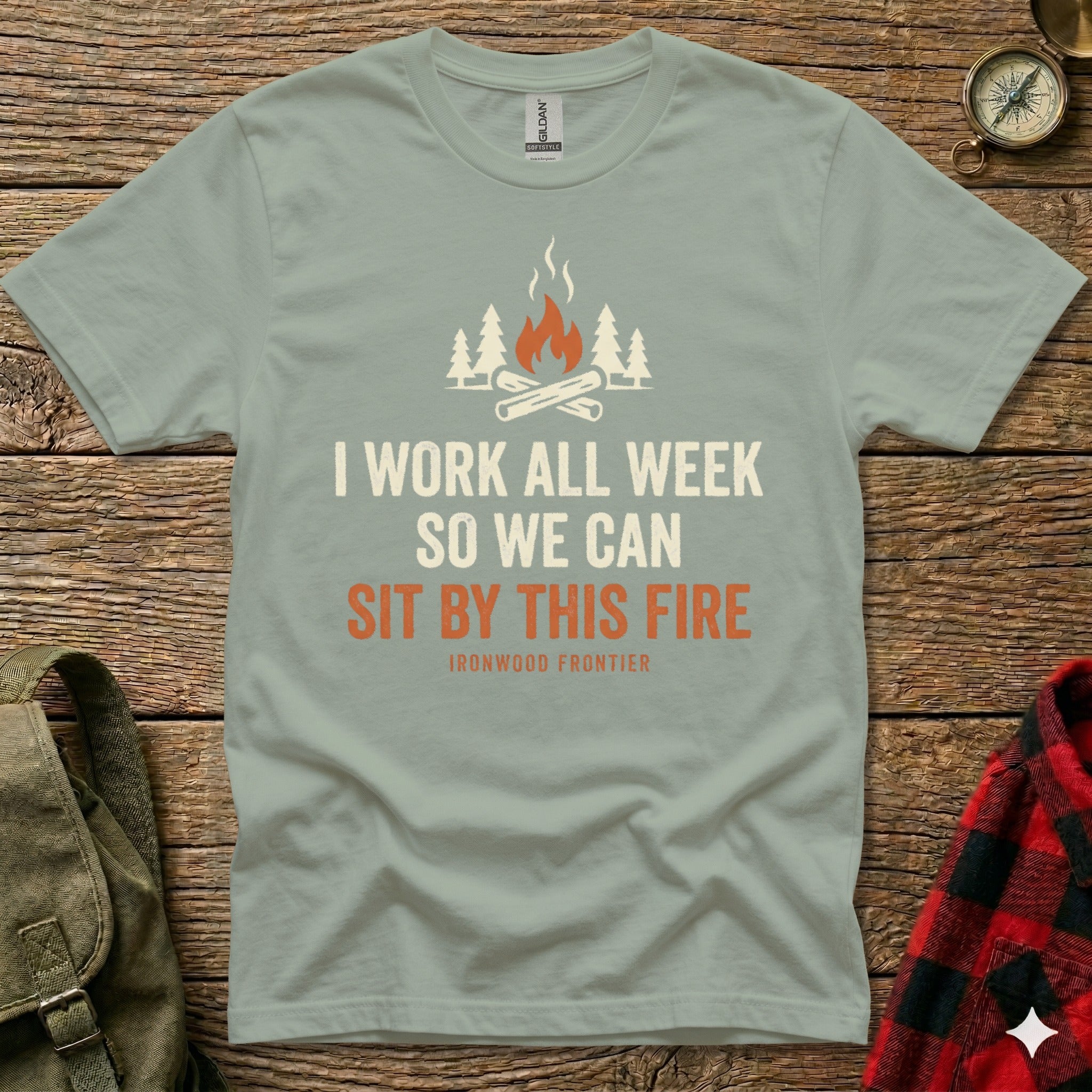 Green t-shirt with campfire graphic and "I Work All Week So We Can Sit By This Fire" text.