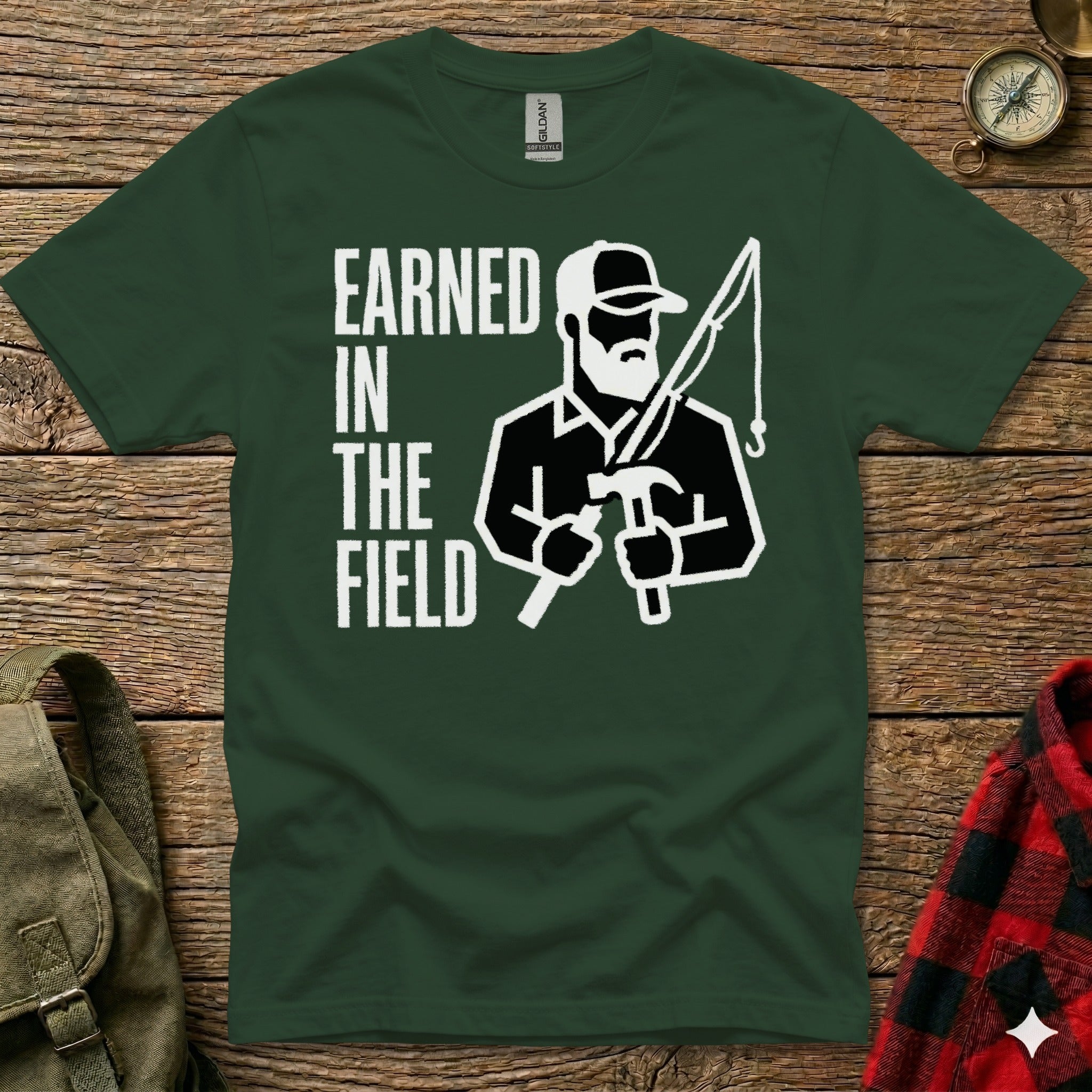 T-shirt with "Earned in the Field" and graphic of a bearded man fishing and hammering.