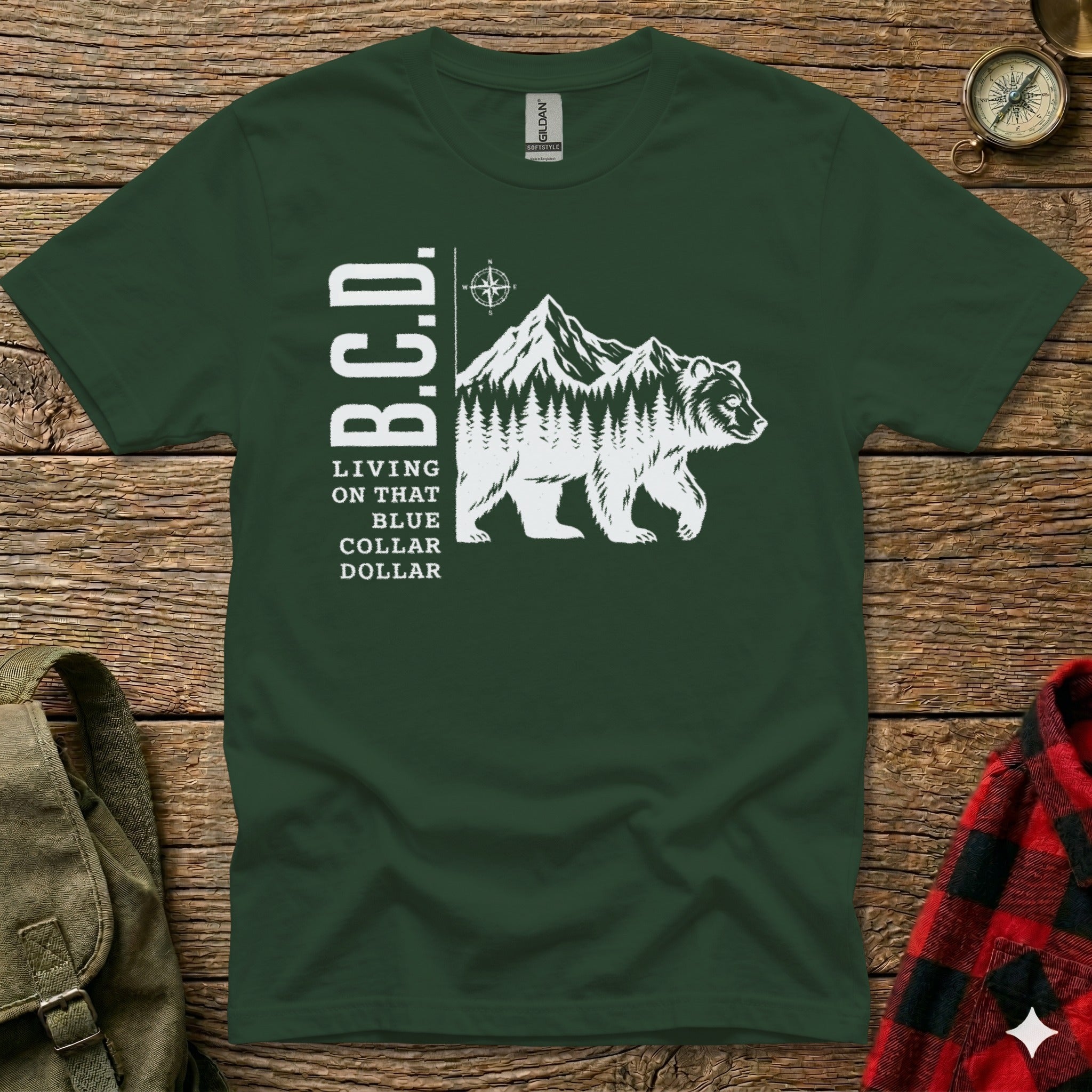 Dark green t-shirt with "B.C.D." and a bear with mountains and text "LIVING ON THAT BLUE COLLAR".