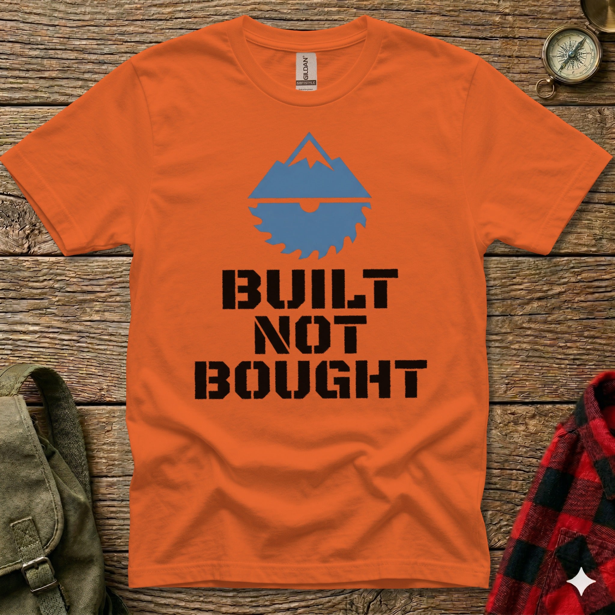 Orange t-shirt with "BUILT NOT BOUGHT" text and mountain graphic.