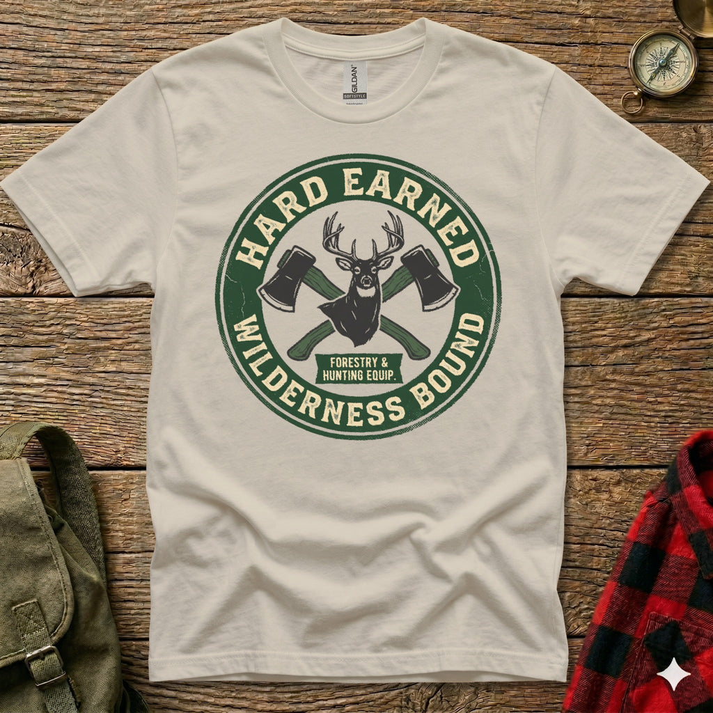 T-shirt with green circular logo, "Hard Earned" and "Wilderness Bound" text, crossed axes.