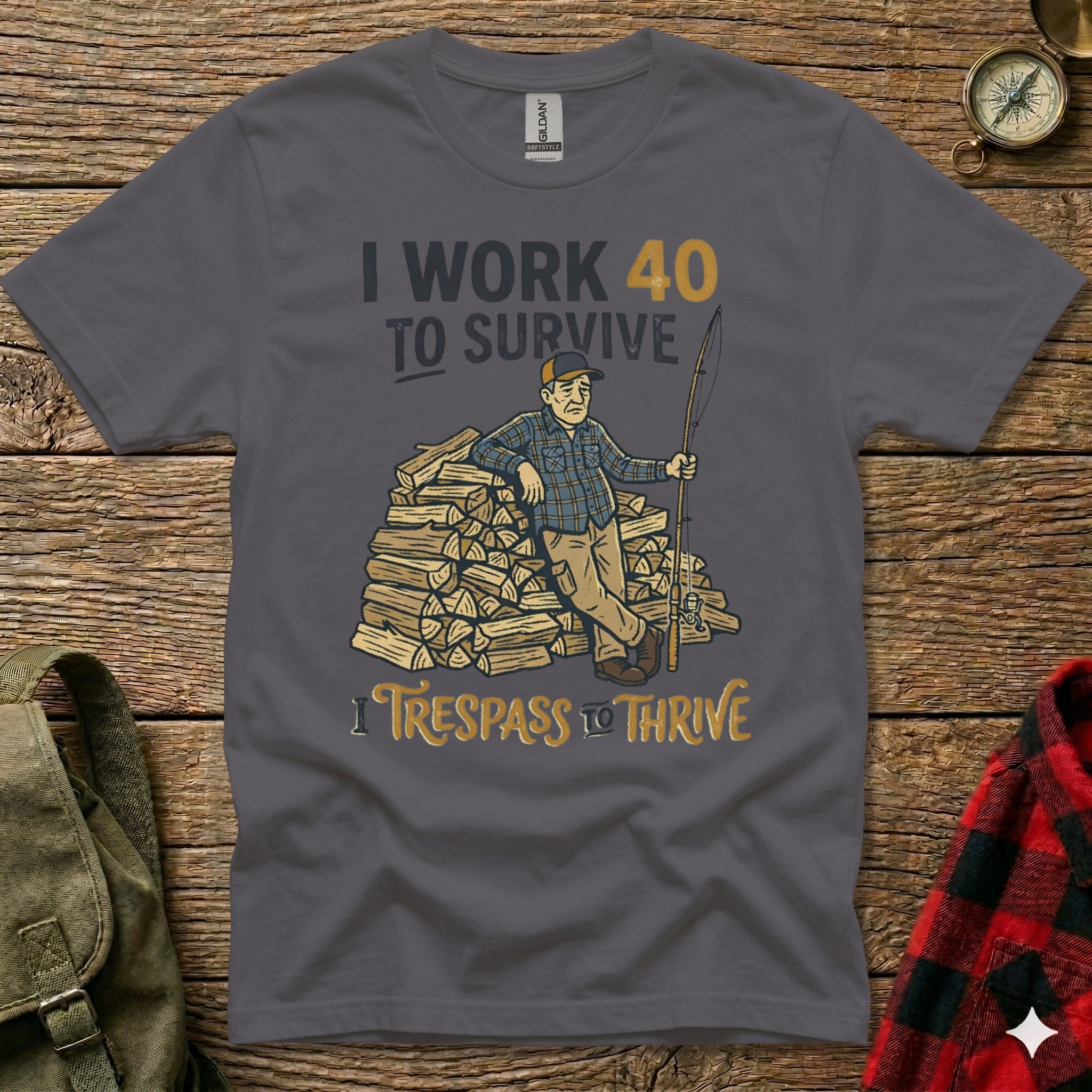 Dark grey t-shirt with "I WORK 40 TO SURVIVE" and "I TRESPASS TO THRIVE" text.