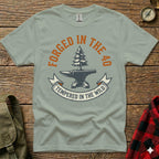 Green t-shirt with "Forged in the 40, Tempered in the Wild" and an anvil.