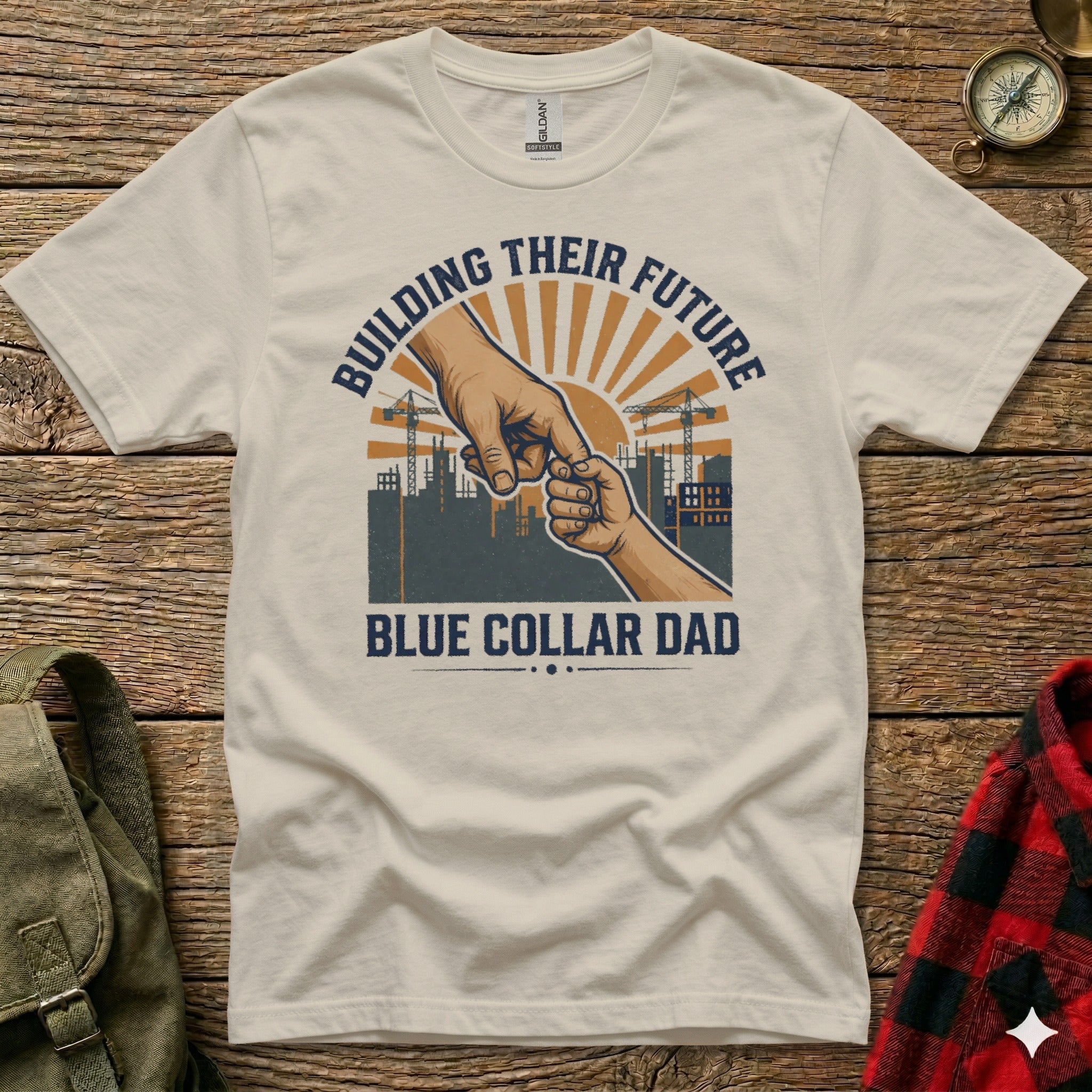 T-shirt graphic: Hand holding child's hand, construction scene, "Building Their Future Blue Collar Dad".