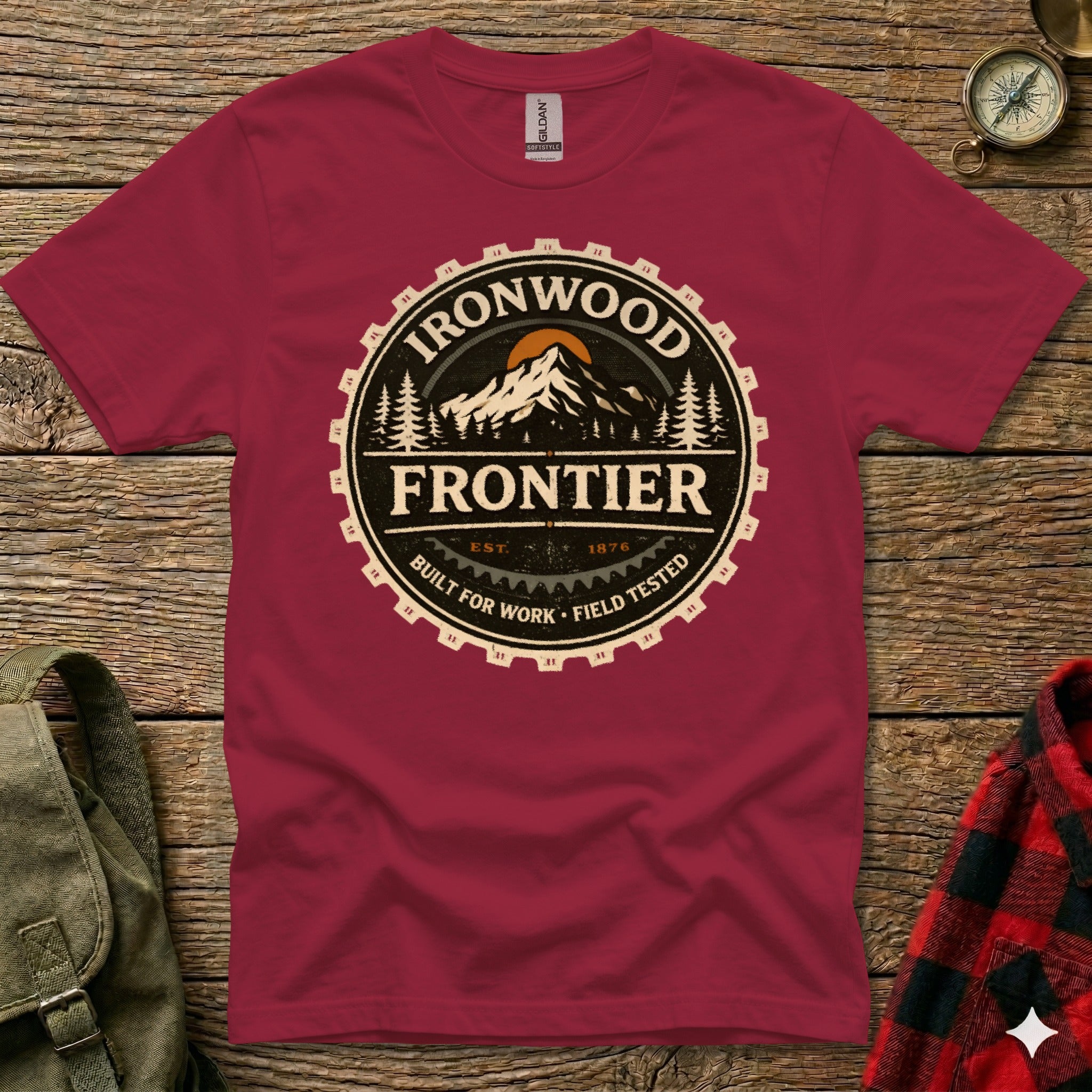 Maroon t-shirt with "Ironwood Frontier" logo, featuring mountains and gear design.