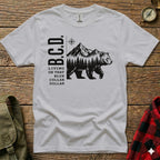 White t-shirt with B.C.D. logo, bear, and mountains.