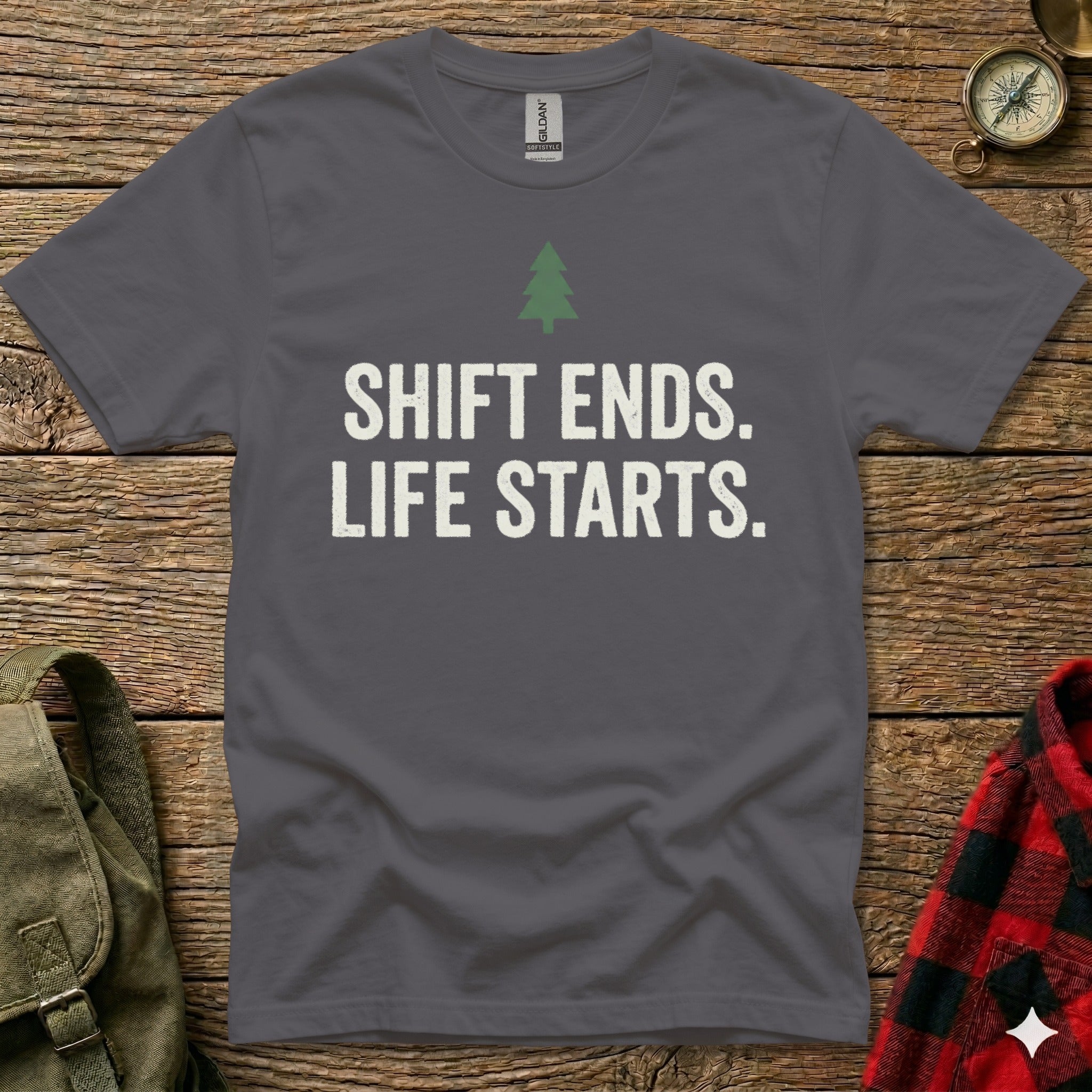 Dark grey t-shirt with white text "SHIFT ENDS. LIFE STARTS." and a green tree icon.