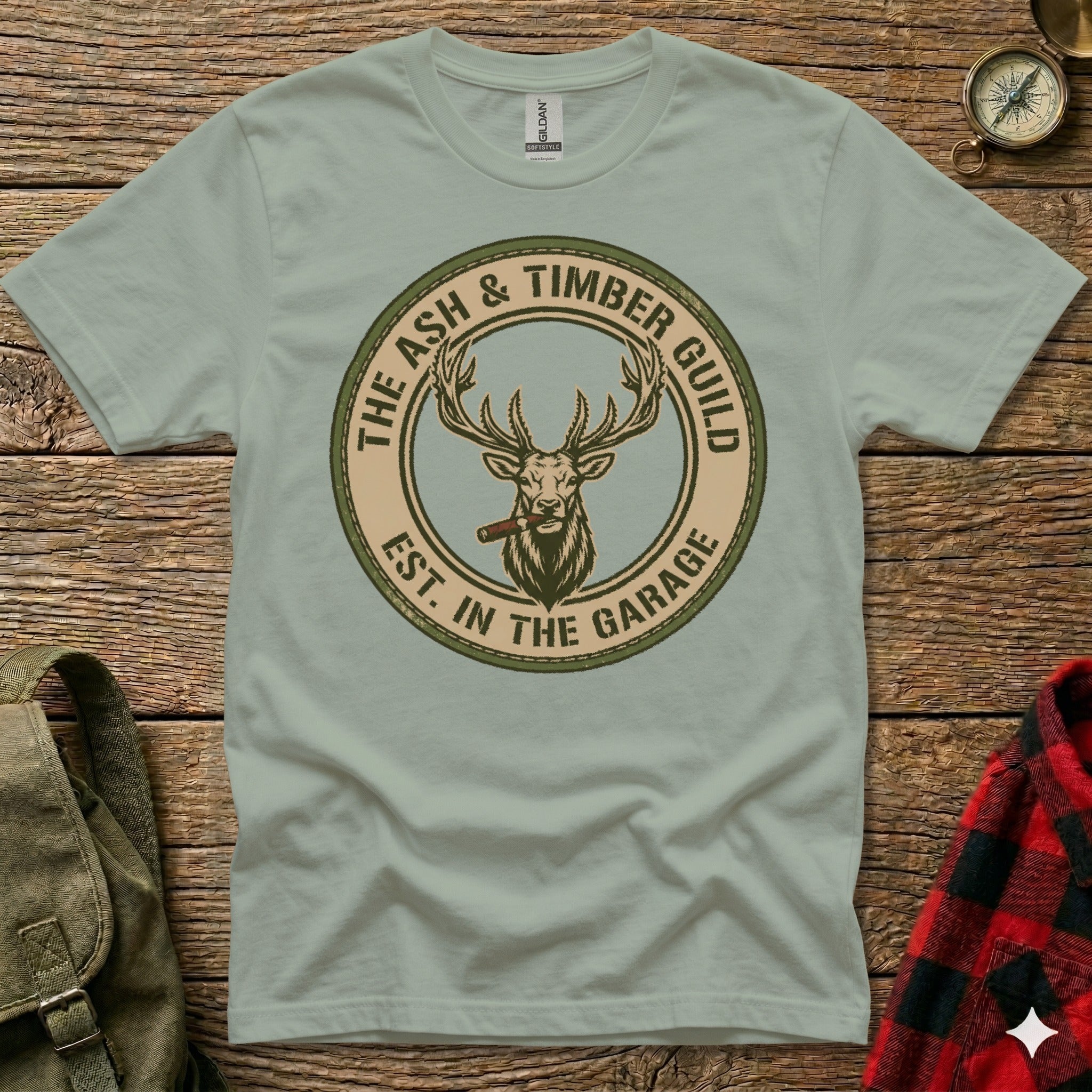 T-shirt featuring a circular logo with a stag and "The Ash & Timber Guild Est. in the Garage".