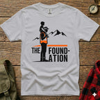 White t-shirt with graphic of man carrying child on shoulders, mountains, and text.
