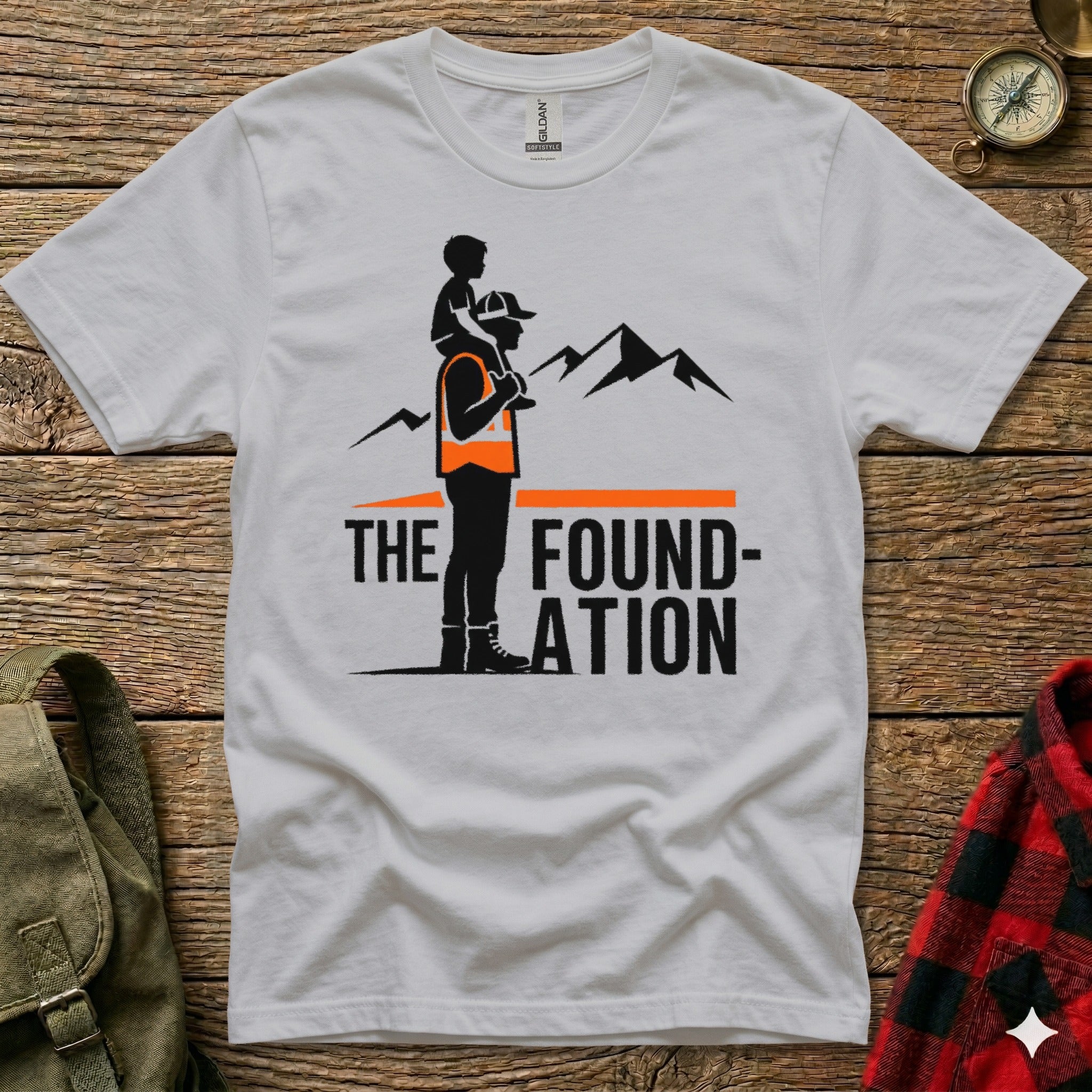 White t-shirt with graphic of man carrying child on shoulders, mountains, and text.