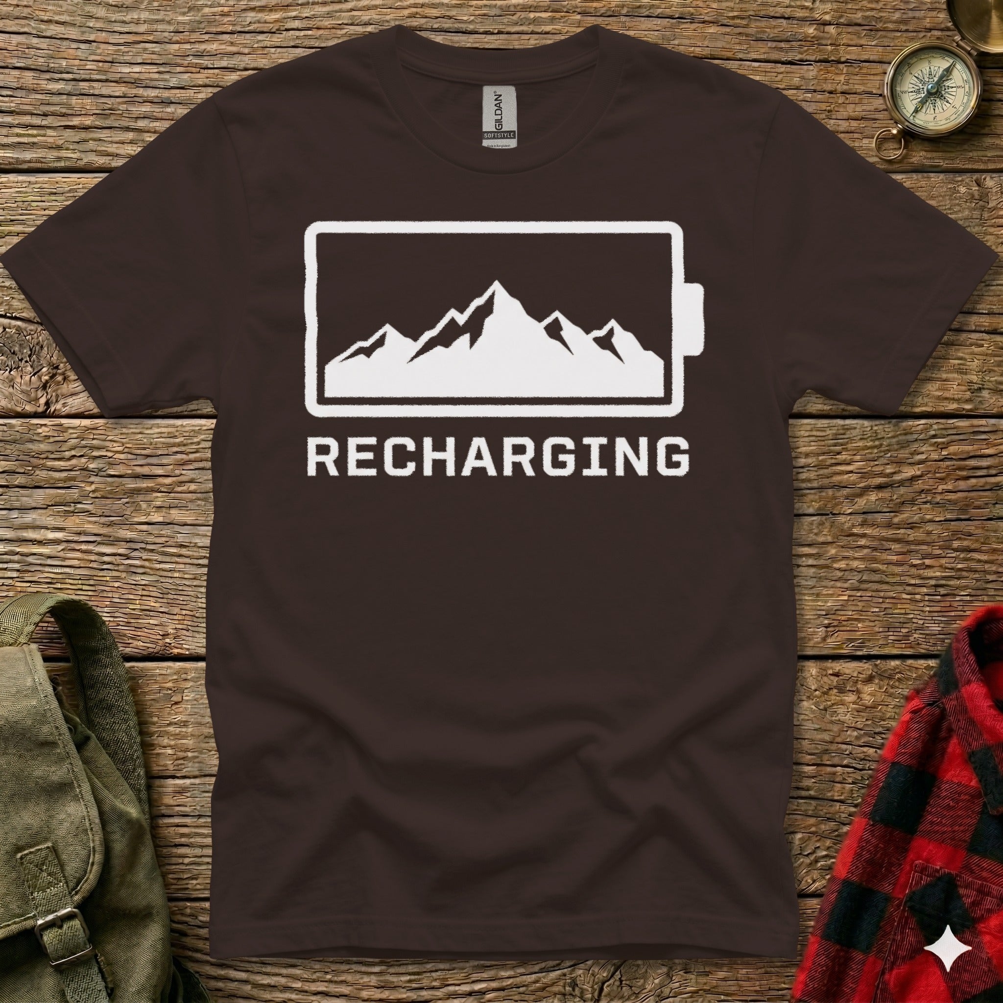Brown t-shirt with a battery icon filled with mountains and the text "RECHARGING".
