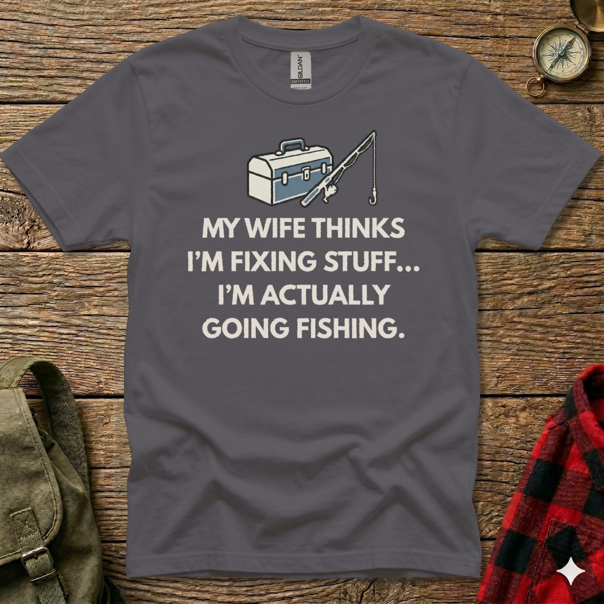 Dark grey t-shirt with "My wife thinks I'm fixing stuff... I'm actually going fishing." text.