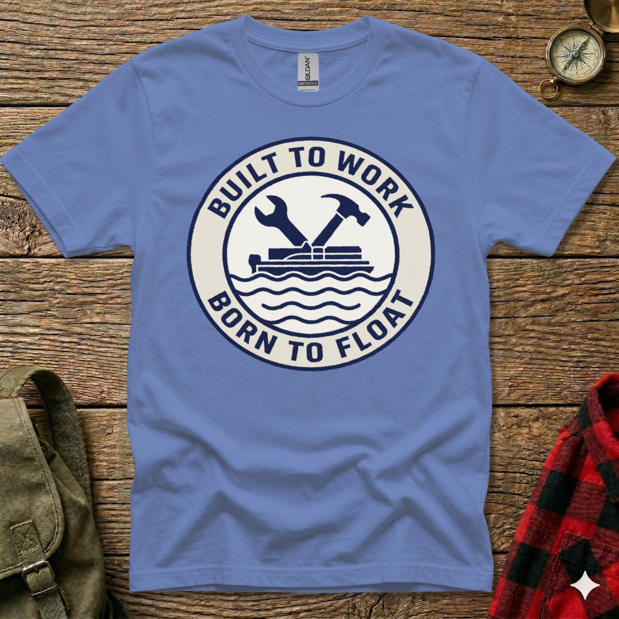 Blue t-shirt with circular logo: "BUILT TO WORK BORN TO FLOAT" and wrench/hammer.