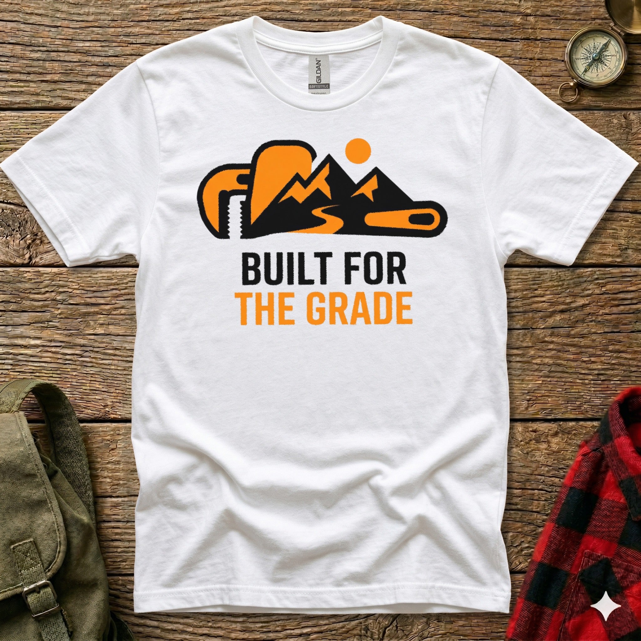 White t-shirt with orange mountain and wrench graphic, "Built for the Grade" text.