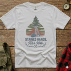 White t-shirt with a pine tree, sunset, and tools graphic and text.