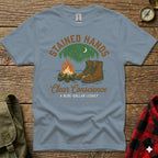 T-shirt with campfire, hiking boots, and "Stained Hands Clear Conscience" text.