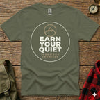 Olive green t-shirt with "EARN YOUR QUIET" and mountain graphic.
