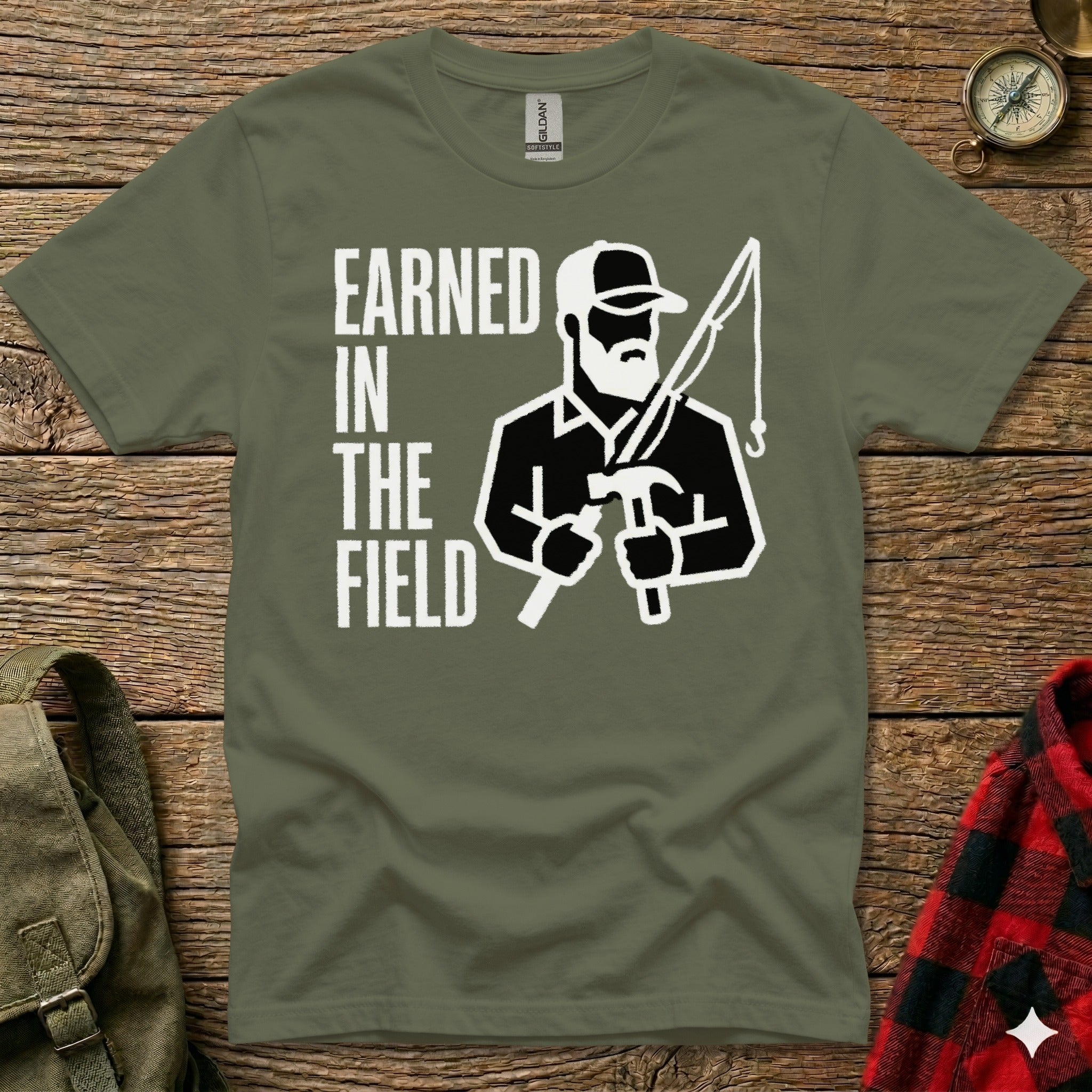 Olive green t-shirt with "EARNED IN THE FIELD" and a fisherman illustration.
