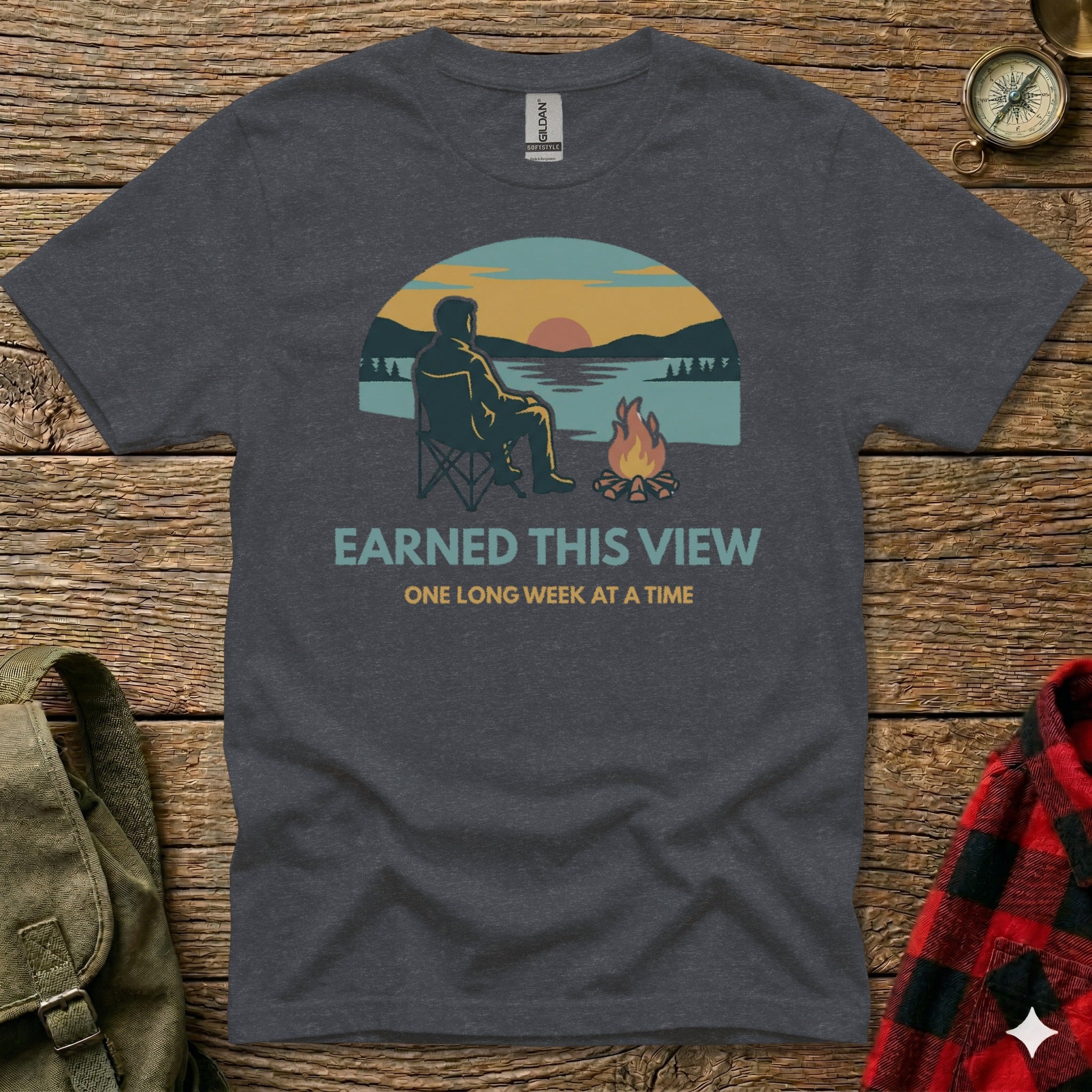 T-shirt with graphic of person by campfire watching sunset.