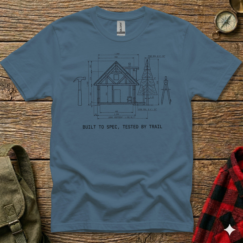 T-shirt with diagram of a cabin, tools, and text "BUILT TO SPEC, TESTED BY TRAIL".