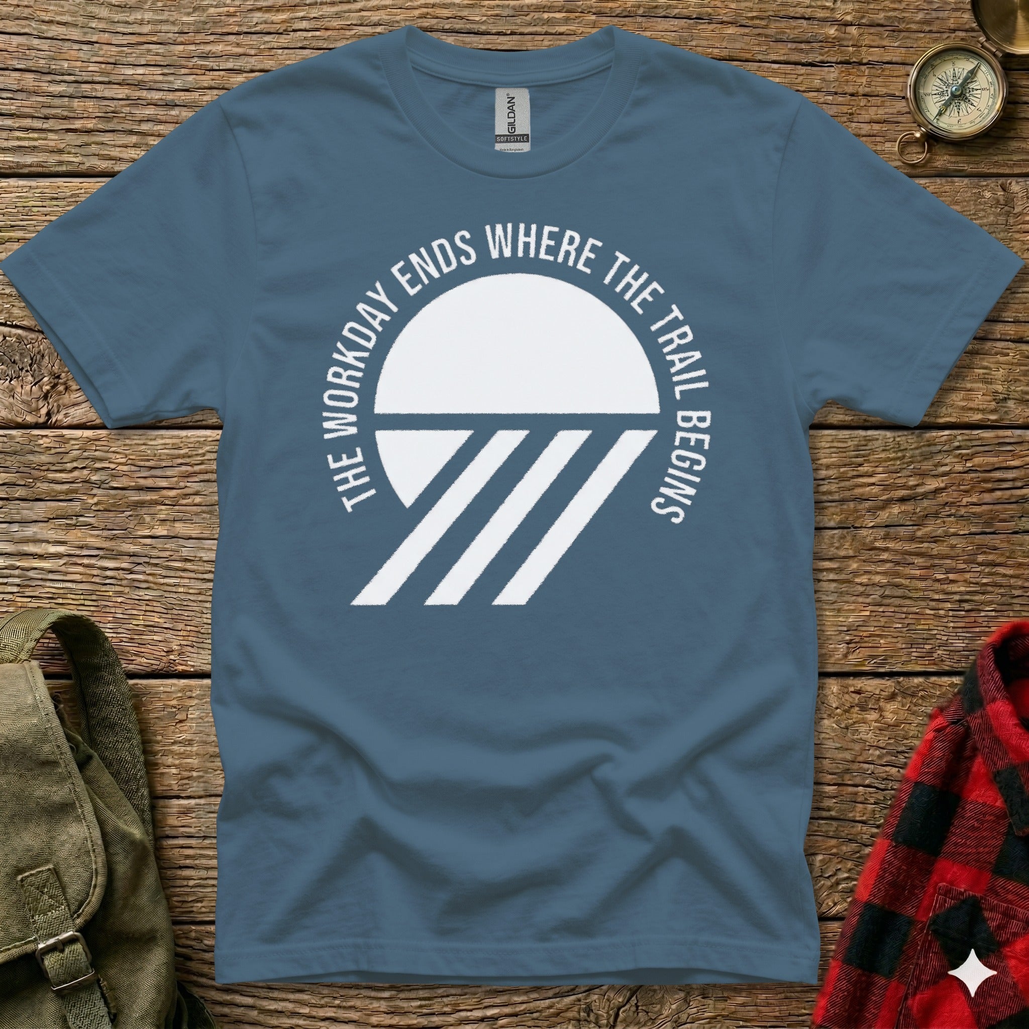 Blue t-shirt with "The Workday Ends Where the Trail Begins" text and abstract mountain graphic.