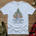 White t-shirt with "Stained Hands. Still Soul." text and tree graphic.