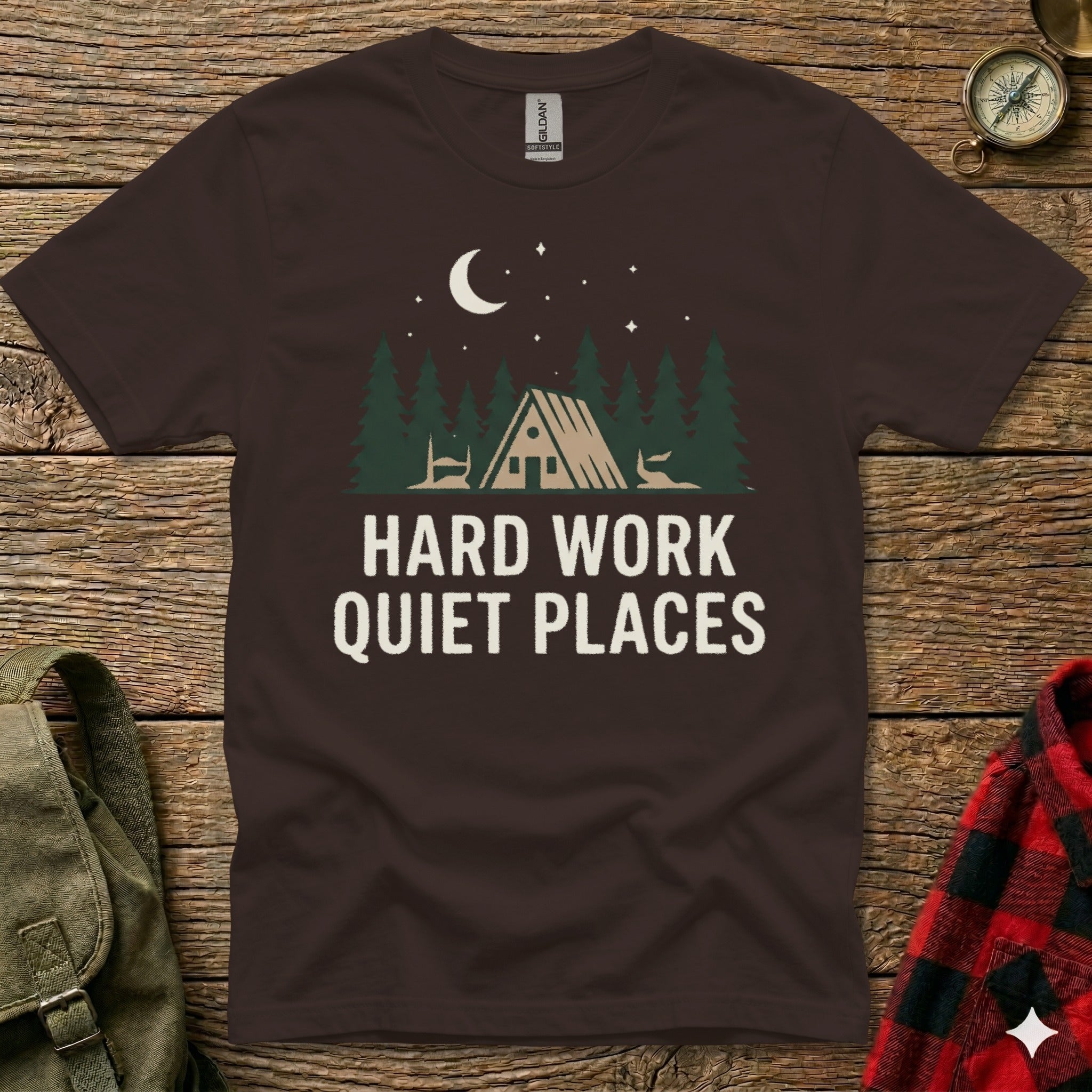 Dark brown t-shirt with "HARD WORK QUIET PLACES" text and forest scene.