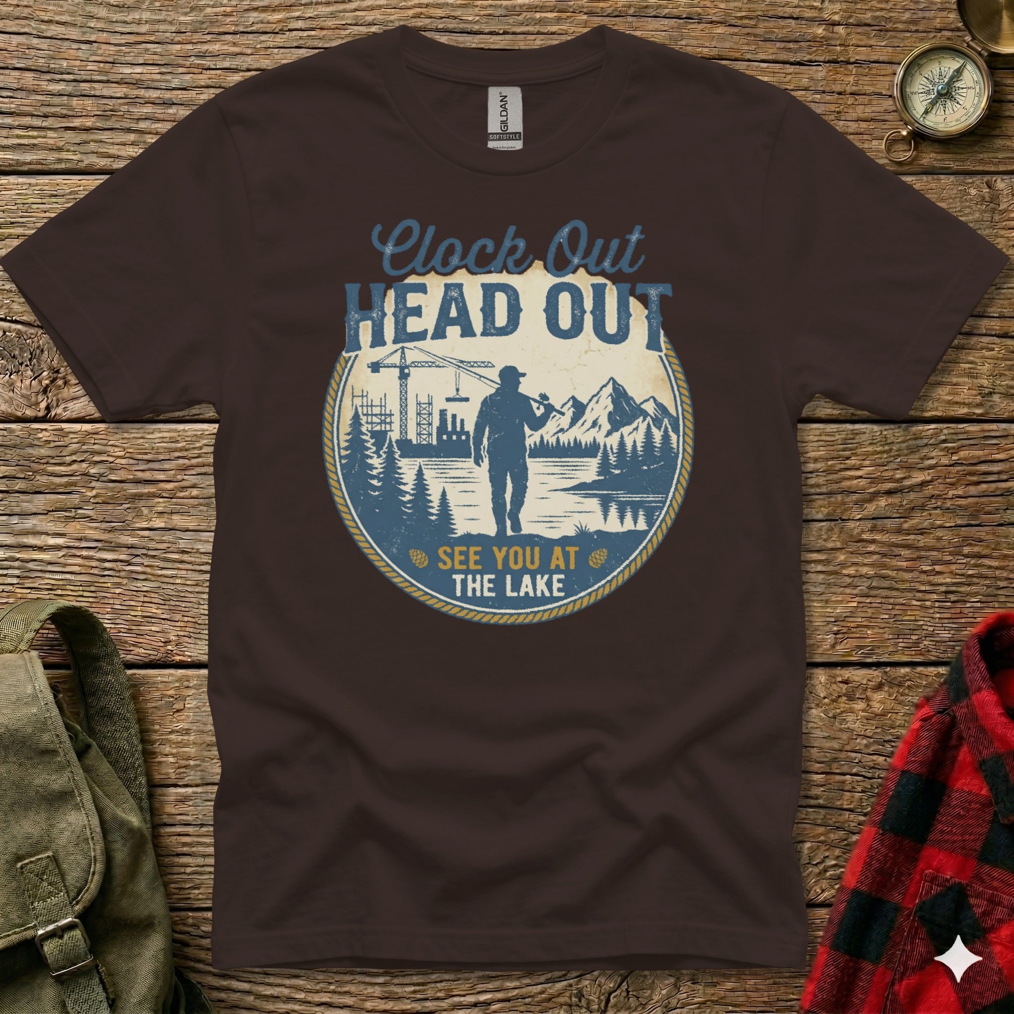 Brown t-shirt with "Clock Out Head Out See You At The Lake" text and circular graphic.