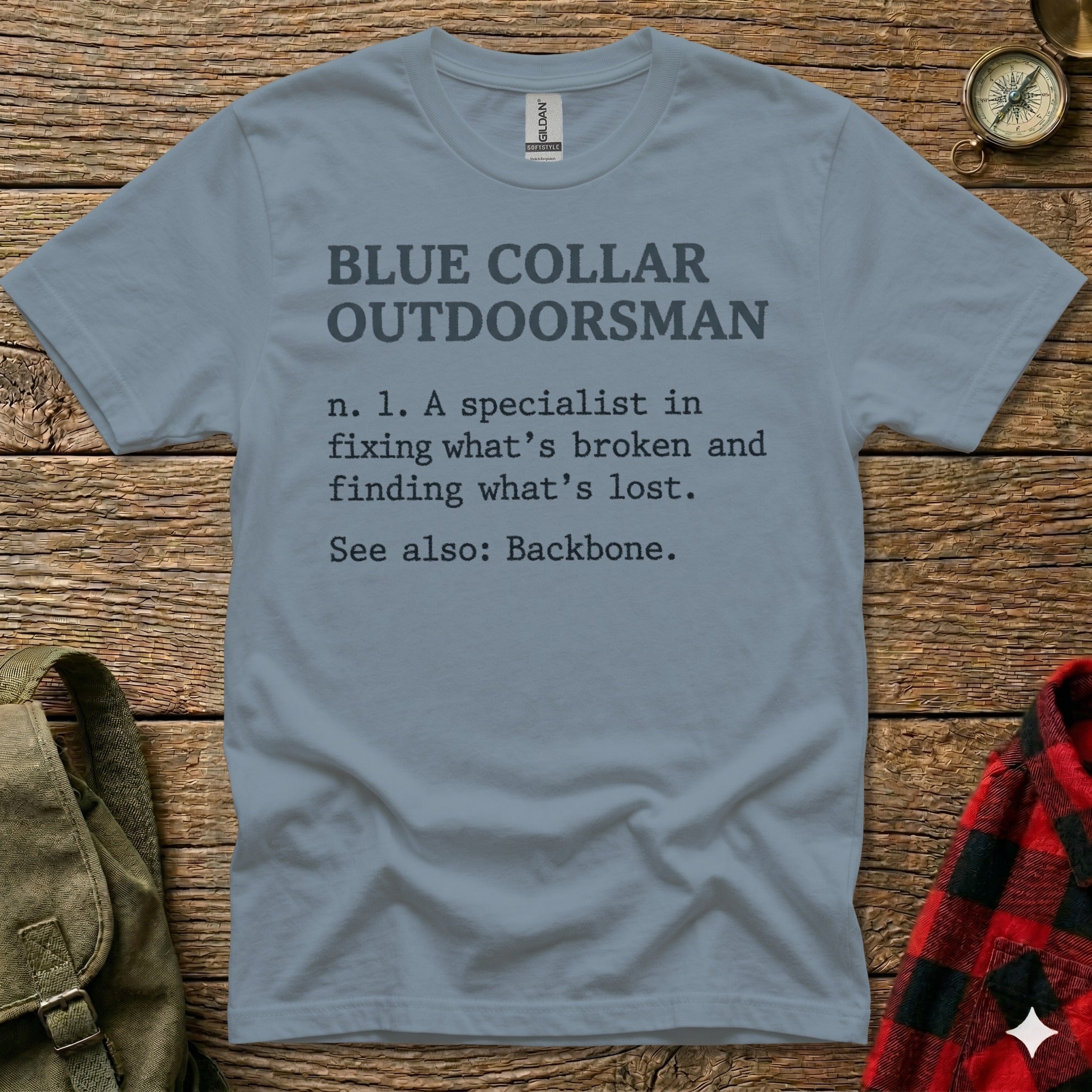 Blue Collar Outdoorsman definition t-shirt on a wooden background.