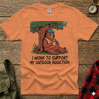 Orange t-shirt featuring a bear in a hard hat drinking coffee, with text "I WORK TO SUPPORT MY OUTDOOR ADDICTION".