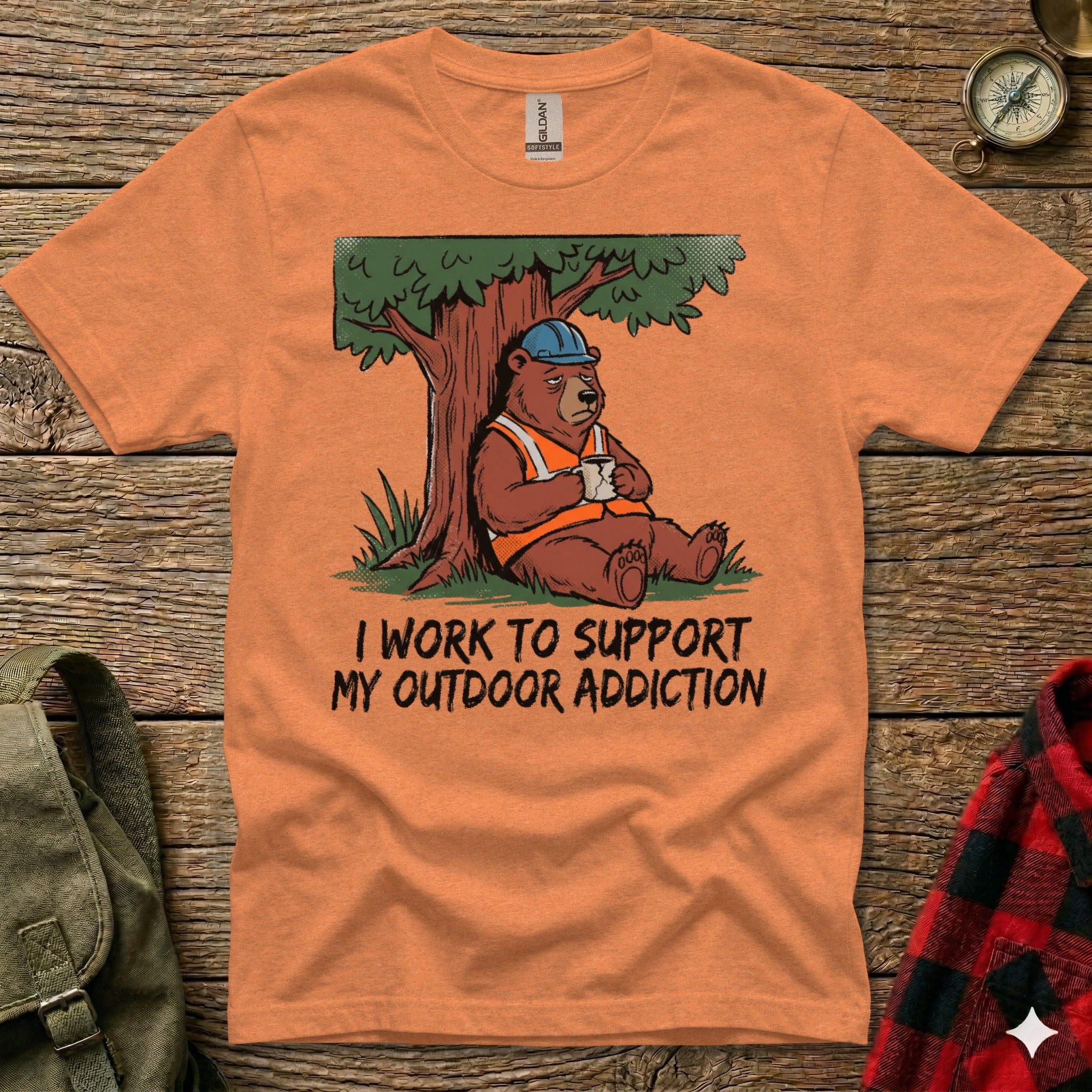 Orange t-shirt featuring a bear in a hard hat drinking coffee, with text "I WORK TO SUPPORT MY OUTDOOR ADDICTION".