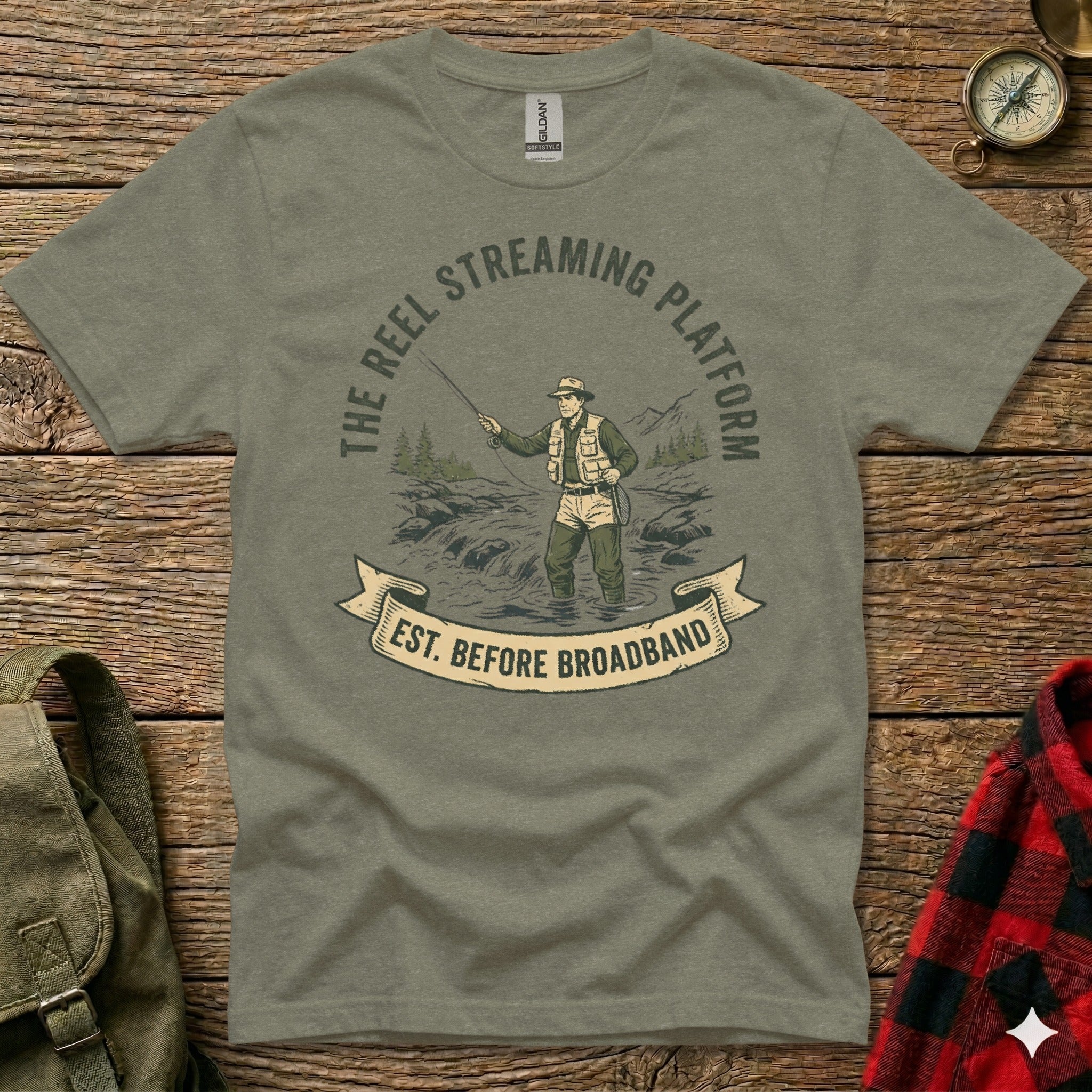 T-shirt graphic: angler fishing with "The Reel Streaming Platform est. before broadband" text.